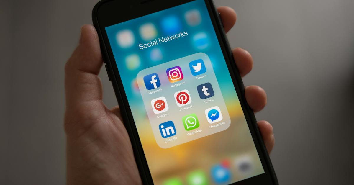 person mit iphone die den ordner fur soziale netzwerke anzeigt